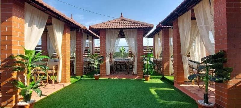 Viraasat rooftop in daylight — brick gazebos, open sky